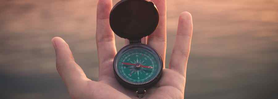 A hand holding a compass, to indicate that the page requested was not found but we hope to help you navigate to the information you need.